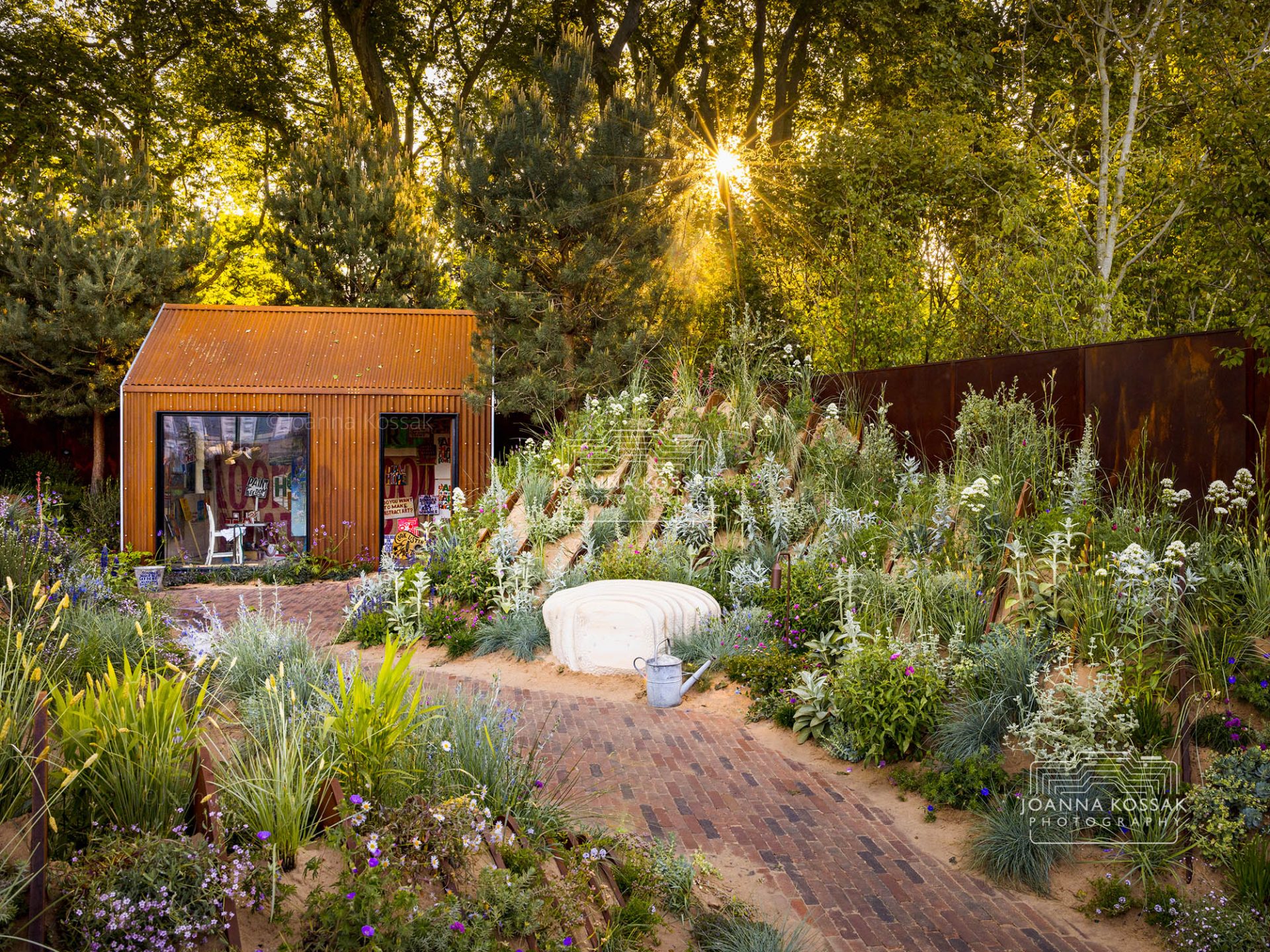 Nigel Dunnett's Hospitalfield Arts Garden at RHS Chelsea Flower Show 2025, captured at sunrise with dune-like sand forms and textured coastal planting