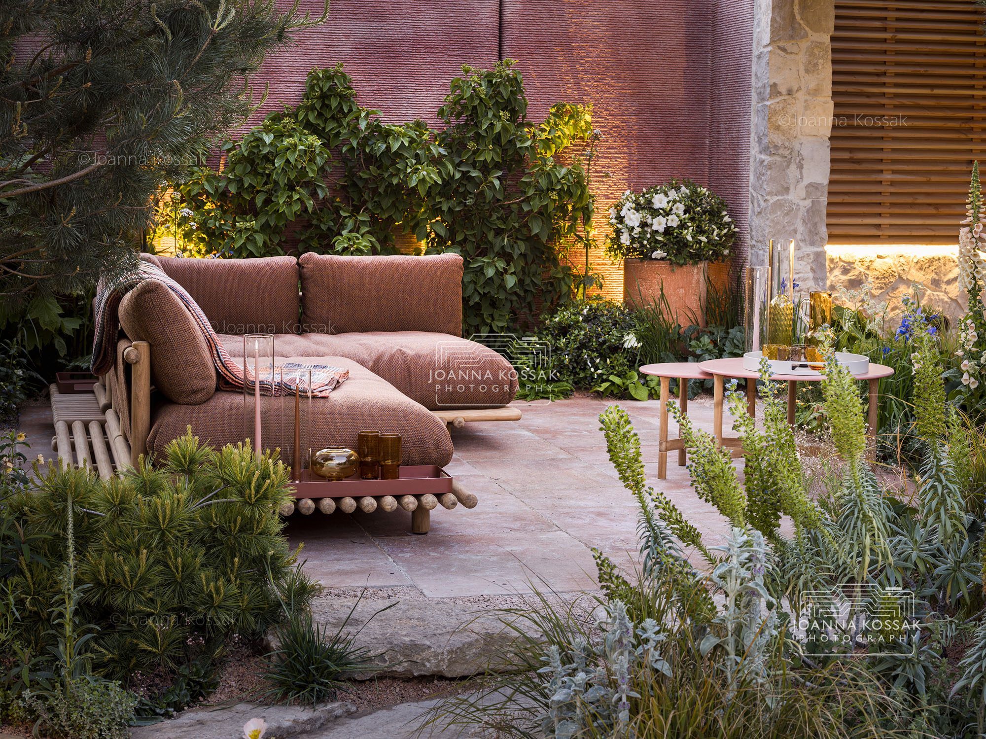 Outdoor sofa seating area in Chelsea garden at dusk with pink elements